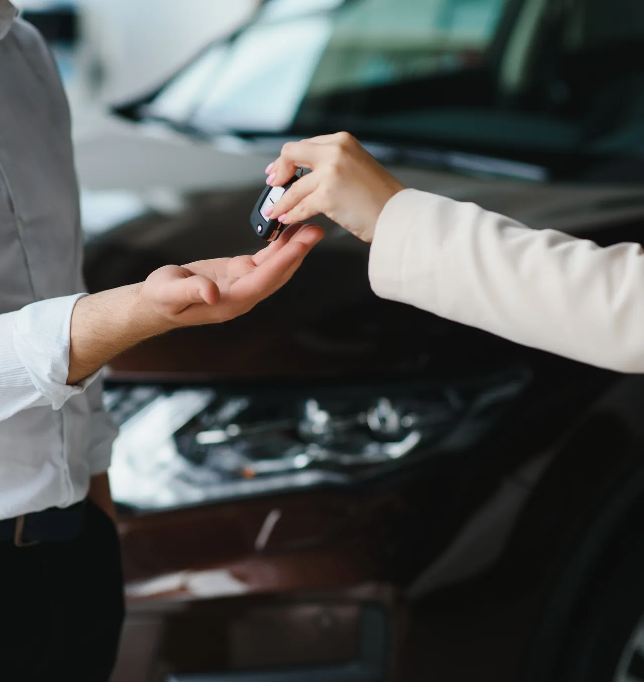Une personne qui remet ses clés de voiture à une autre personne.